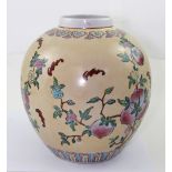 A modern Oriental peach ground baluster vase with Famille Rose flora and foliate decoration with