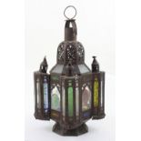 A late 19th/early 20th century Moroccan metal lamp with glass panels and later applied pieces of