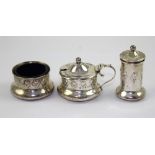A George V hallmarked silver three-piece condiment set comprising salt, pepper pot and mustard,
