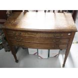 A mid-20th century oak three-drawer cutlery table to tapering supports and peg feet,