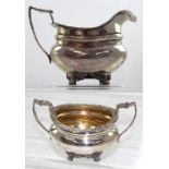 An Edward VII hallmarked silver sucrier and milk jug with bear mask terminals, Chester 1906,