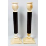 A pair of Art Deco ivory and cherry amber candlesticks with spreading square sectioned bases, turned