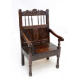 A late 17th century oak Wainscot chair with carved shaped top rail above row of spindles (one