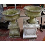 Two composite garden urns with two associated plinths (4).