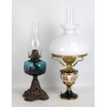 An oil lamp on pierced foliate motif stand with blue glass reservoir and clear chimney, height 45cm,