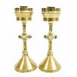 IN THE MANNER OF A W N PUGIN; a pair of brass Gothic Revival candlesticks, the knopped columns