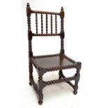 A 17th century bobbin-turned oak side chair with spindle set top rail above plank seat and