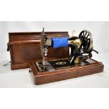 A walnut-cased Singer sewing machine.