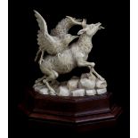 A late 19th century carved ivory figure group of an eagle upon the back of a stag upon rocks,