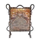 An Arts and Crafts beaten copper and wrought iron fire screen with central panel set with stylised