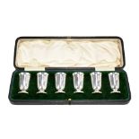 CHARLES EDWARDS; a cased set of six George V hallmarked silver tot cups, with flared rim on tapering