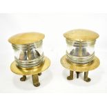 A pair of brass and clear glass ship's lamps with ribbed central section and brass tripod bases,