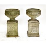 A pair of reconstituted garden urns on stands, height 74cm.