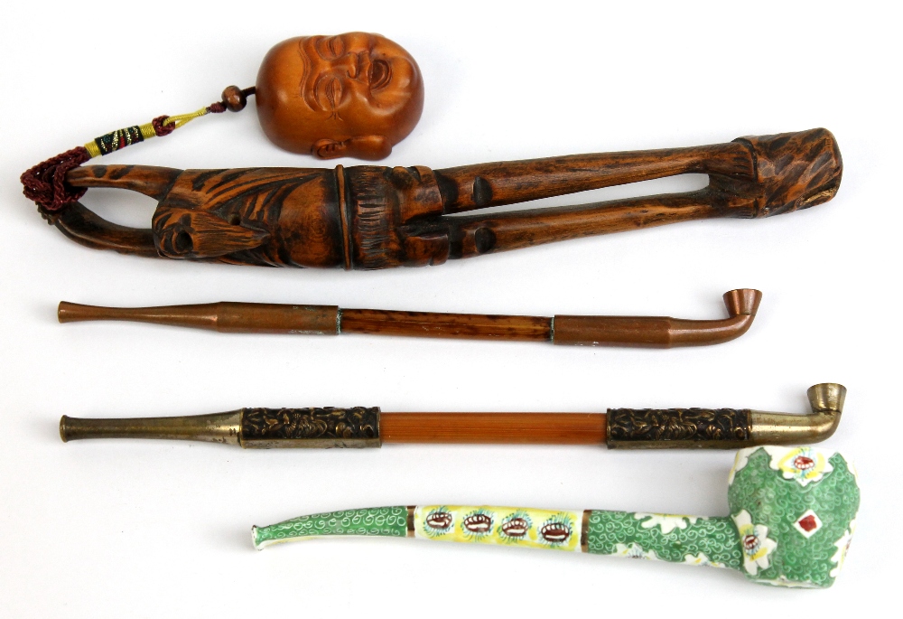 An enamelled pipe and a Japanese pipe held in an unusual carved box wood frame, with a smaller