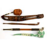 An enamelled pipe and a Japanese pipe held in an unusual carved box wood frame, with a smaller