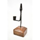 An 18th century wrought iron rush light in rectangular stepped elm base, height 21cm.