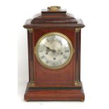 An early 20th century mahogany cased mantel clock, the silvered dial set with Roman numerals, the