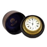 A brass cased circular travelling clock with enamel face set with Roman and Arabic numerals, in a