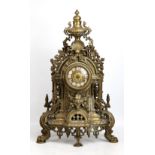 A decorative brass mantel clock with ornate pierced frame, height 61cm (lacking hands).