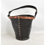 A late 18th/early 19th leather fire bucket with stud decorated copper bands and leather strap
