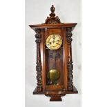 An early 20th century walnut and stained beech spring-driven Vienna wall clock with back plate