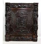 A Victorian carved oak rectangular panel incorporating 17th century elements with central cherubic