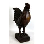A large carved wooden cockerel, with traces of paint, height 45cm.