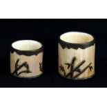 A pair of Japanese Meiji period ivory brush washers with metal mounts decorated with birds amongst