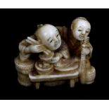 A Japanese Meiji period carved ivory netsuke of two figures eating, signed to base, length 4.2cm.