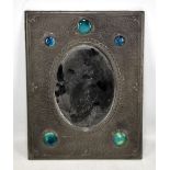 An Arts and Crafts pewter mounted rectangular mirror with hammered finish and inset Ruskin high