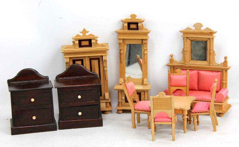 A collection of dolls' house furniture including a set of light wooden furniture with pink silk