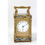 A small French brass cased carriage clock with enamelled detail, the circular dial set with Arabic