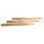 A 9ct yellow gold propelling pencil and two gold plated examples (3).