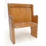 A small Victorian pine pew with shaped end supports and simple seat.