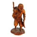 A Japanese Meiji period carved boxwood okimono of a gentleman with basket upon his back, signed to