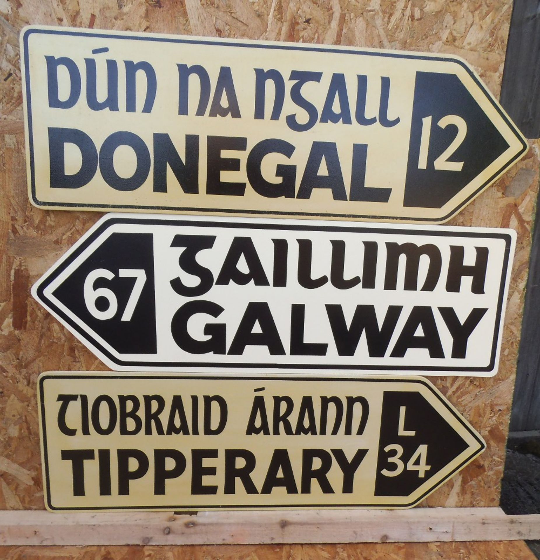 Three replica wooden Irish road signs, 90 x 30cm.