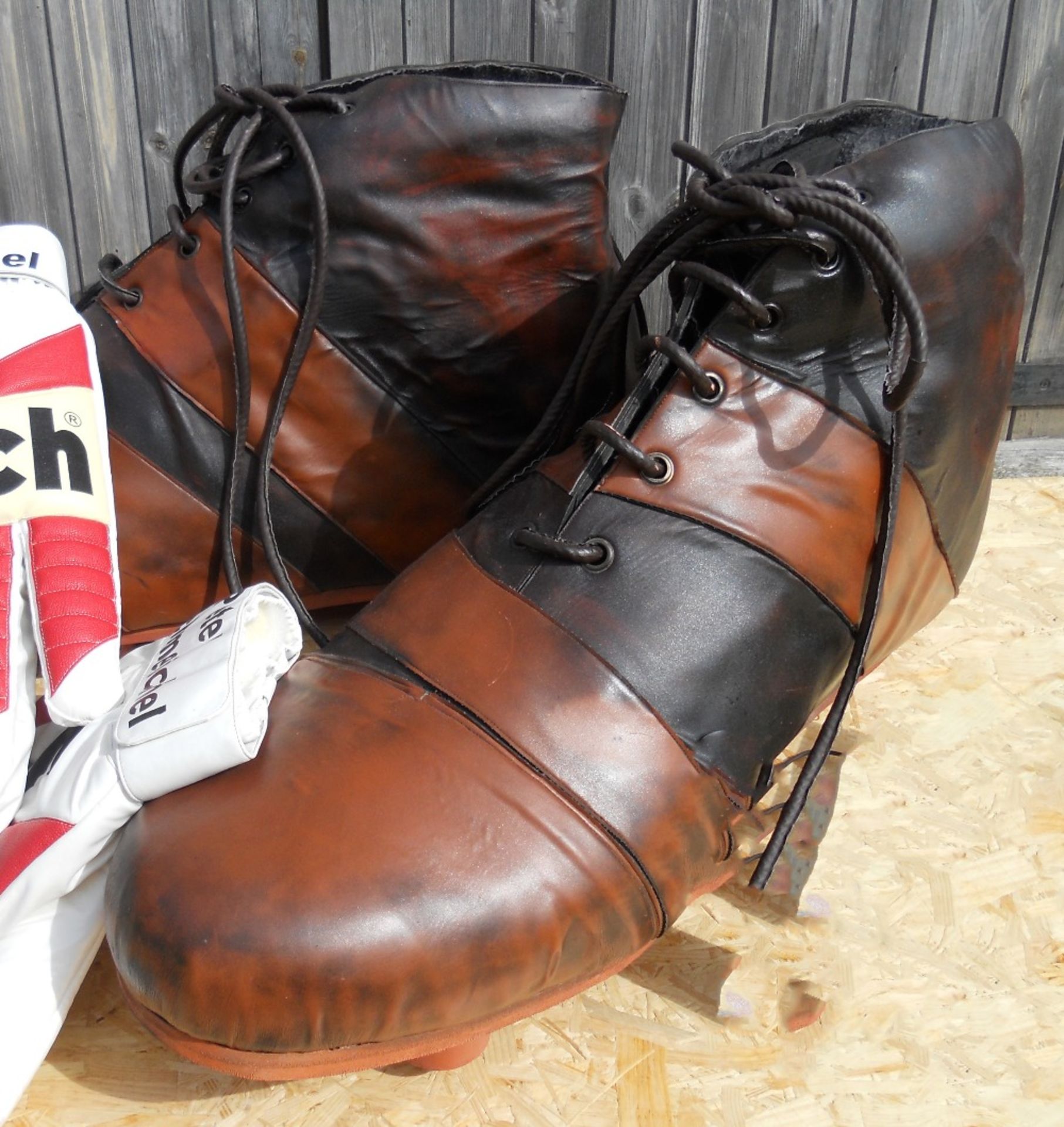 A pair of giant sized black and brown football boots, length 100cm.