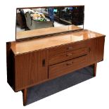 A 1960s teak laminate dressing table with central bank of three drawers flanked by twin cupboards,