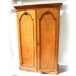 A Victorian satin walnut two-door rounded-corner wardrobe with arched panel doors and flared