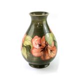 A Moorcroft green ground baluster vase with tube-lined hibiscus pattern,