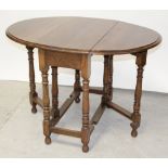 A stained oak drop-leaf table on turned gate-leg supports, width 75cm.