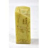 A Chinese green hardstone square section seal engraved with figural landscape with rocks and trees,