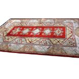 A russet ground Anatolian carpet with central stylised floral gul surrounded by a scrolling
