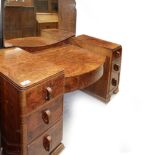 A c1950s walnut Art Deco style mirror-back kneehole dressing table, central bow-front drawer,