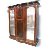 A c1900 mahogany inlaid bow-front twin mirrored door wardrobe,