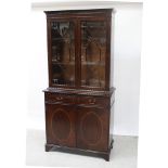 A 20th century mahogany reproduction elevated bookcase on a two-drawer and two-door cupboard base,