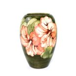 A Moorcroft green ground ovoid vase with tube-lined hibiscus decoration,