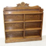 An Edwardian Irish oak floor-standing open bookcase, carved galleried top with central monogram,