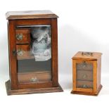 An early 20th century oak smoker's cabinet with glazed door, width 29cm, and a small three door