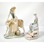 Two Lladró figures of a girl with cow and girl with pigs (2).Additional InformationTip of one piglet